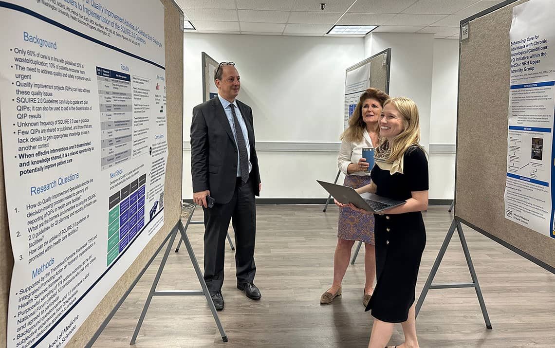 Judges David Scalzitti, Ellen Costello, and Sabrina Figueiredo standing before a research poster