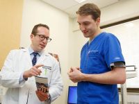 Dr Adam Friedman and colluegue are looking at a pamphlett