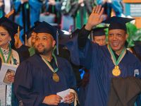 Health Sciences graduates smile and wave to their families at graduation celebration