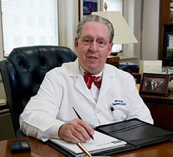 Dr. John Larsen sitting at his desk