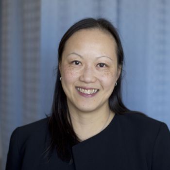 Juliet Lee standing for a portrait in front of a white backdrop