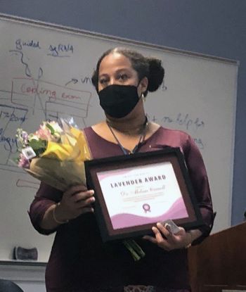 Melissa Carroll holding a flower bouqet and the lavender award