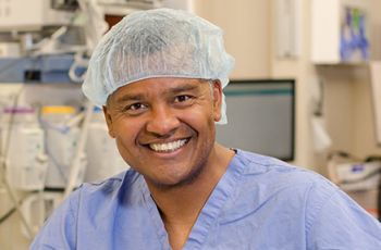 Dr. Joseph Keith Melancon posing for a portrait in surgery scrubs