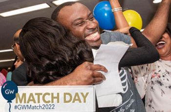 A medical student holding their match day envelope and hugging a family member