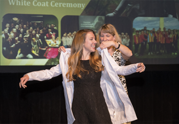 A woman is given a white coat during the PA ceremony