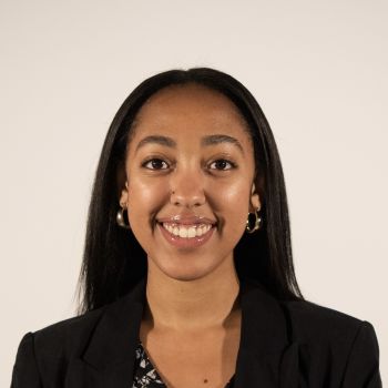 Image of a woman smiling with dark hair wearing a black shirt