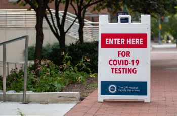 A sign on GW's campus reading 'Enter here for COVID-19 testing'