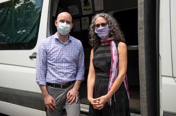 David Diemert, MD, and Manya Magnus, PhD, MPH stand next to each other outside a white van