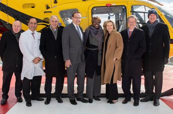 Several GW medical faculty stand in front of a yellow helicopter
