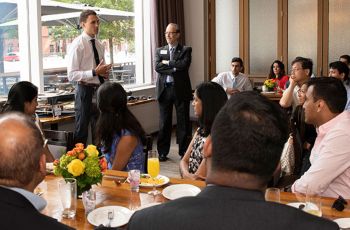A MD student speaks to a crowd of people during a brunch at a restaurant 