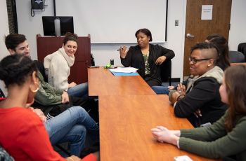 Students sit around a table conducting mock interviews