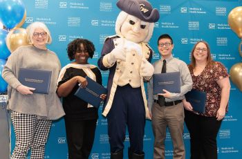 The Dean’s Excellence in Service Award winners stand with the GW mascot
