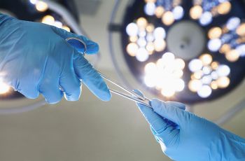 A surgeon receiving a tool in an operating room