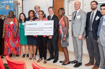Members of the GW MFA standing together and holding a giant CareFirst check for $410,000