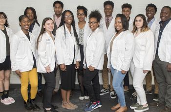 DC HAPP students wearing white coats stand together