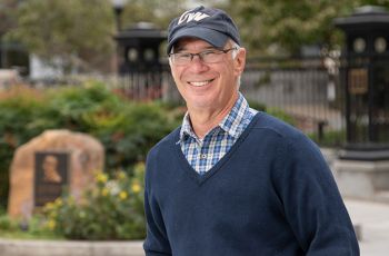 Dr. Gordon Moshman wearing a GW hat and posing for a portrait outdoors