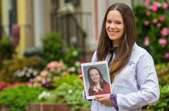 Rising fourth-year MD student Miriam Toaff standing with a photo of her mother