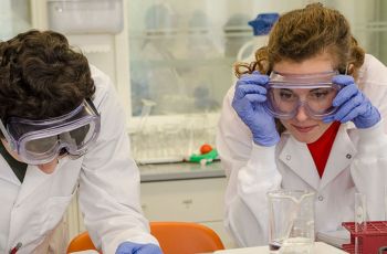 Two researchers in PPE in a lab