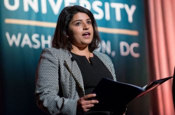 Dr. Sushmita Malik standing on a stage and speaking