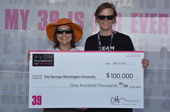 Mandi Pratt-Chapman holding a large $100,000 check from the Avon Foundation