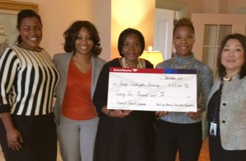 Several Upward Bound faculy standing and holding a check from The Bank of America Charitable Foundation 