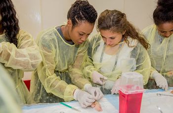 Kaylah Maloney, a medical student instructs DC HAPP participant on suturing technique
