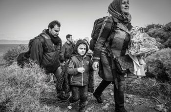 A refugee family walking through bushy terrain