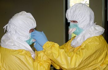 Two people in yellow and white Personal Protective Equipment