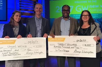 Aubrey Van Kirk Villalobos standing with other competition winners with large checks