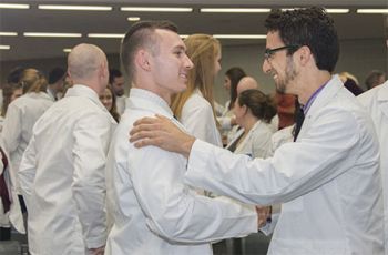 Two students shake hands at the Physical Therapy convocation