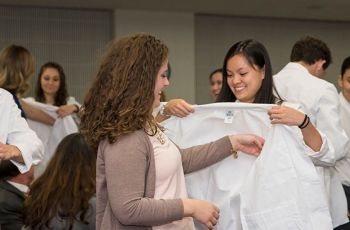 Physical Therapy students putting on white coats