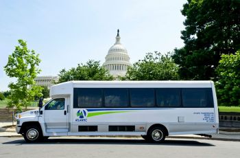 A shuttle bus parked with the U.S. Capitol seen in the distance