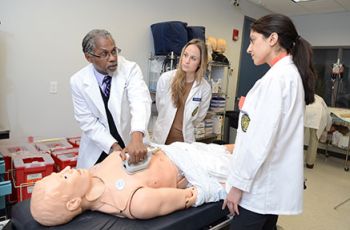 Dr. Howard Straker gives a medical demonstration to students using a dummy