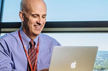 Dr. Stephen J. Teach using a Macbook laptop