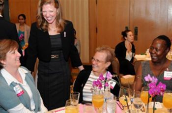 Breast Care Center luncheon participants talking at a table