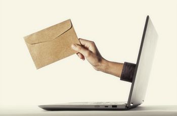 An arm holding a letter emerging from a laptop screen