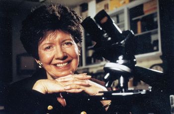 Marilyn Koering posing beside a microscope