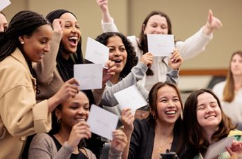 Students in group holding match envelopes
