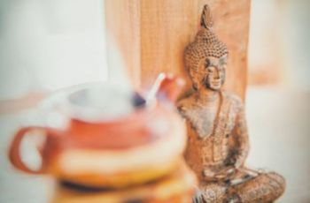 A wooden buddha statue and a teapot