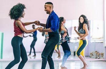 Dance partners dancing samba in a studio