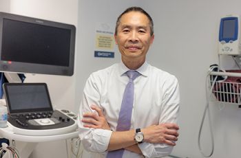 Norman Lee, PhD, in clinic space with arms crossed