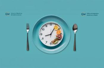 A fork and spoon set around a plate holding a clock