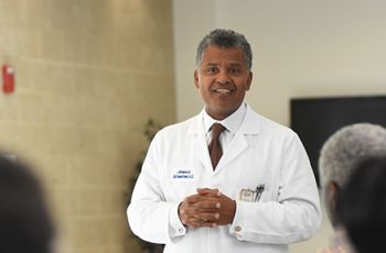 J. Keith Melancon, MD, in white coat speaking