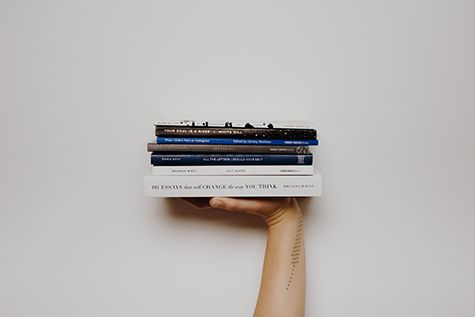 A person holding a stack of books