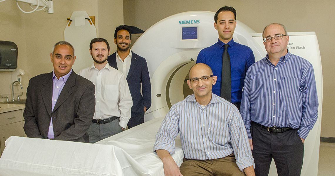 Neuroradiology faculty surrounding an imaging machine