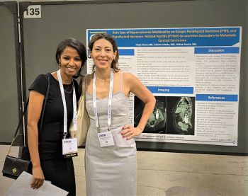 Two fellows posing in front of their research project presentation