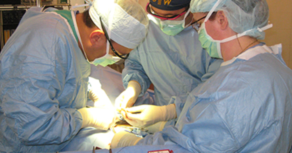 Three doctors performing surgery